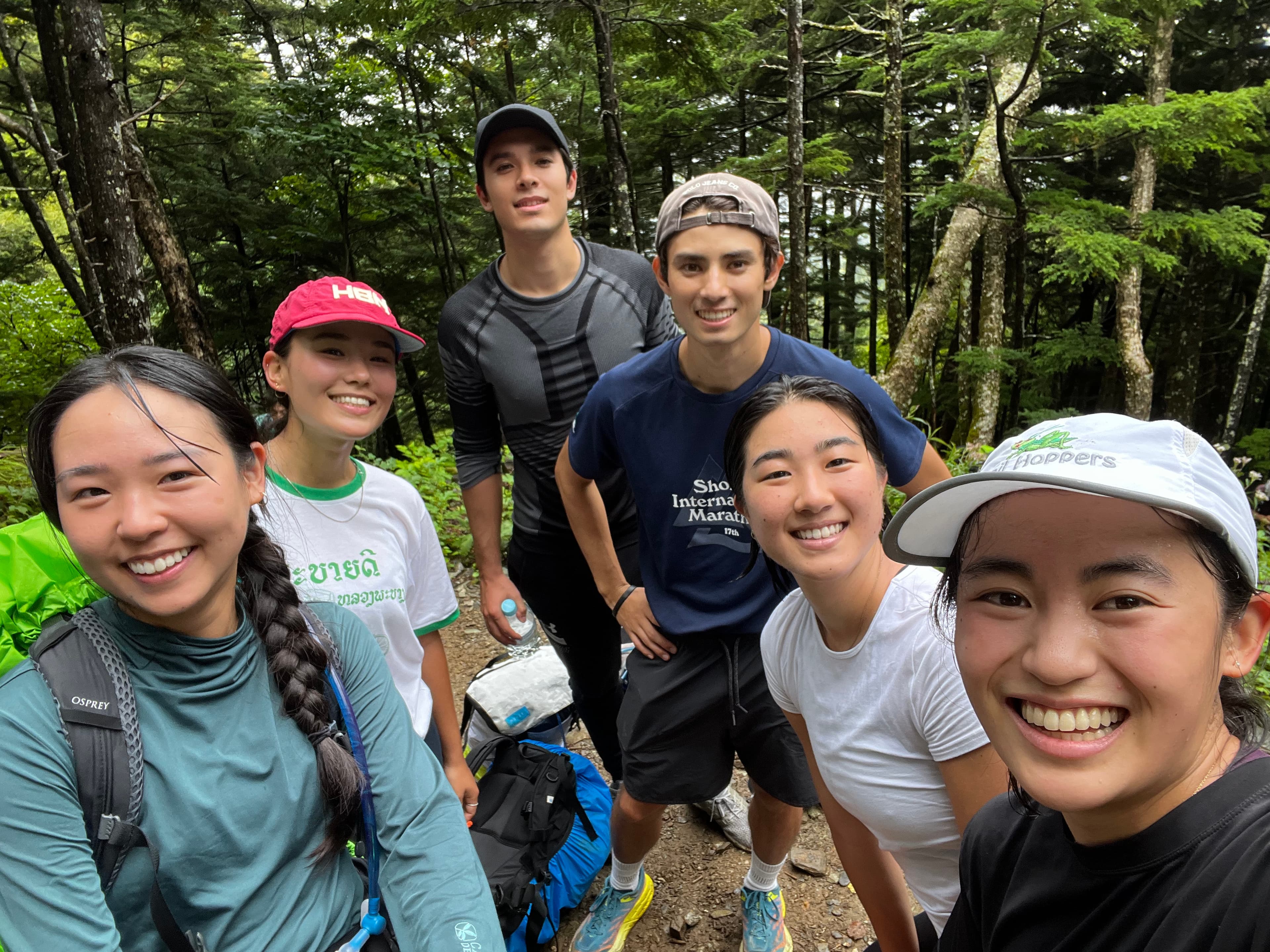 A group of six hikers together in the forest