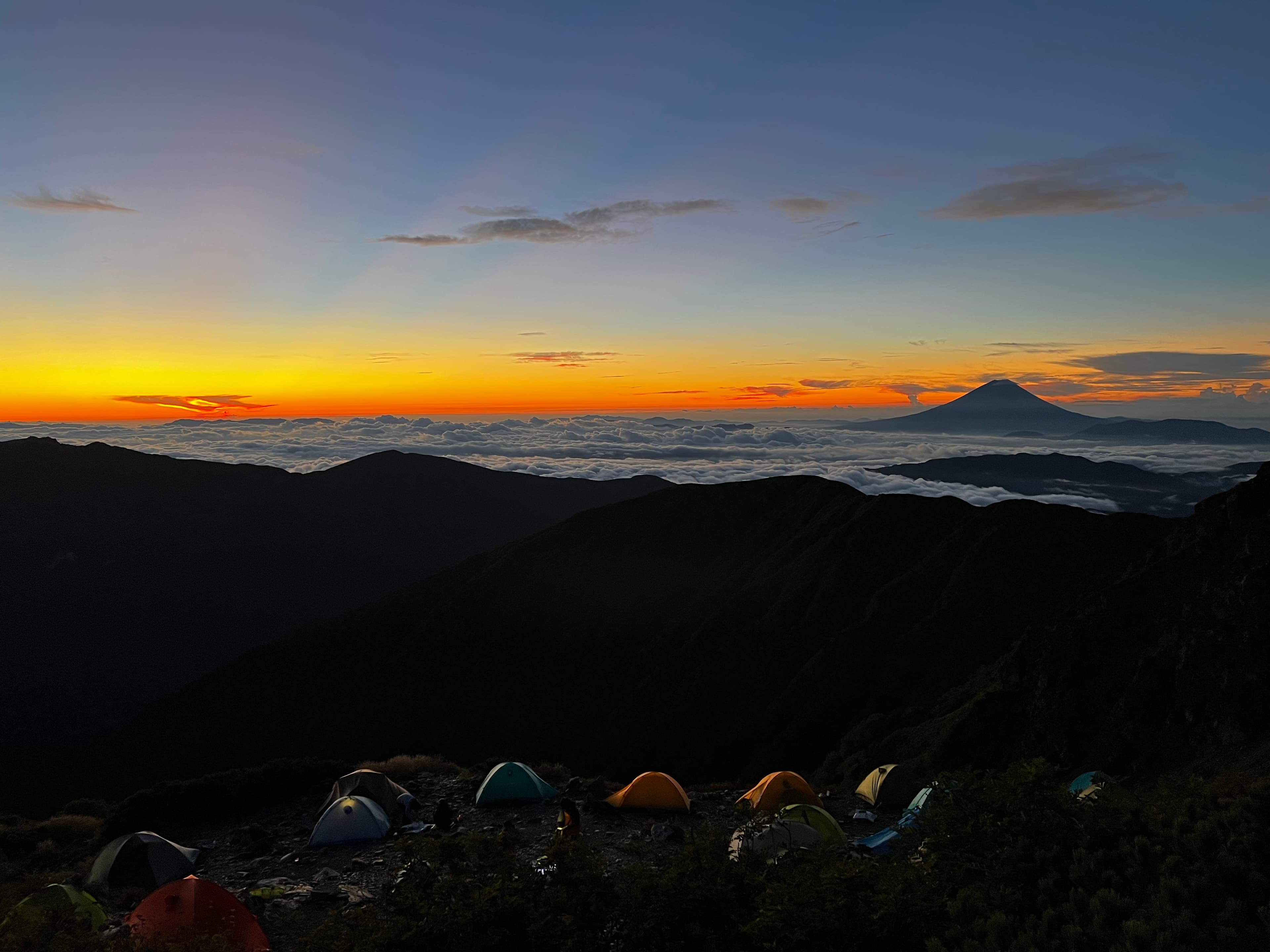 Sunset over the Southern Alps with tents and Mt. Fuji in the distance