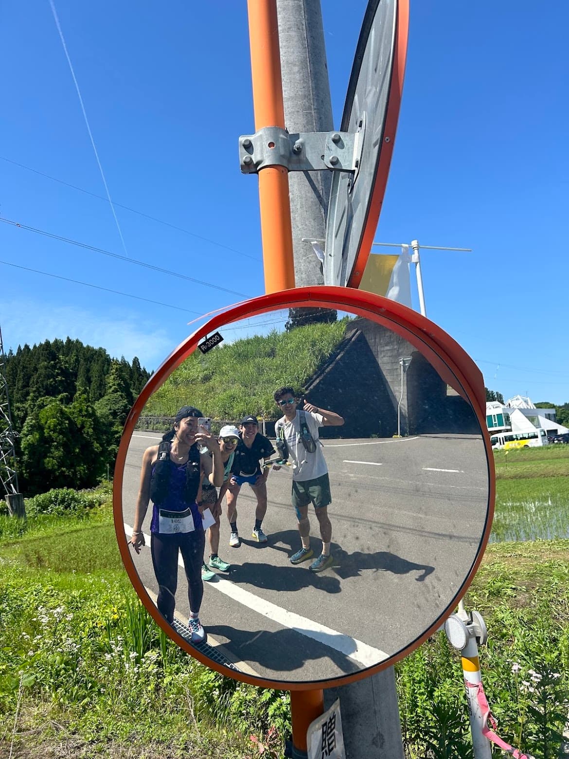 Group of runners reflected in a road mirror