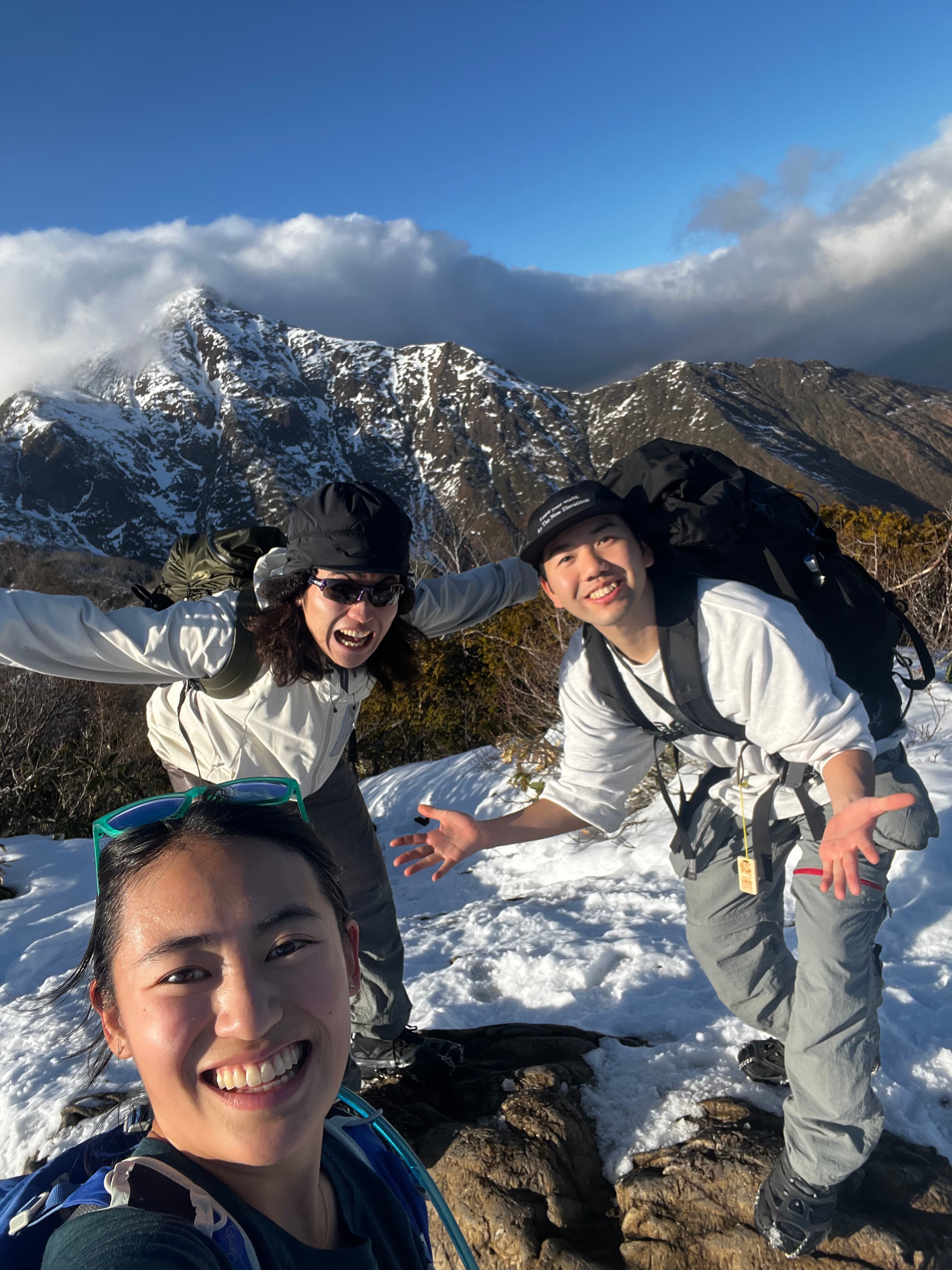 Three friends on a snowy winter summit
