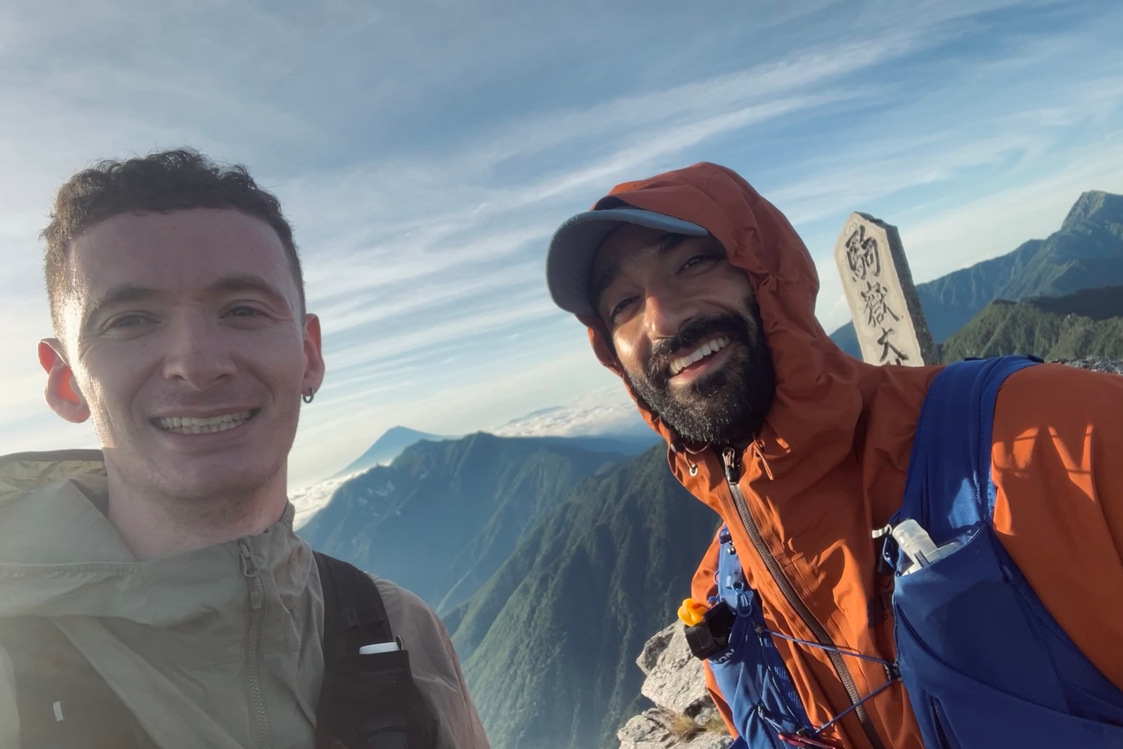 Two runners at an alpine summit